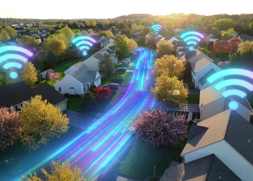 Glowing wifi symbols and speed line graphics illustrated over modern American homes.