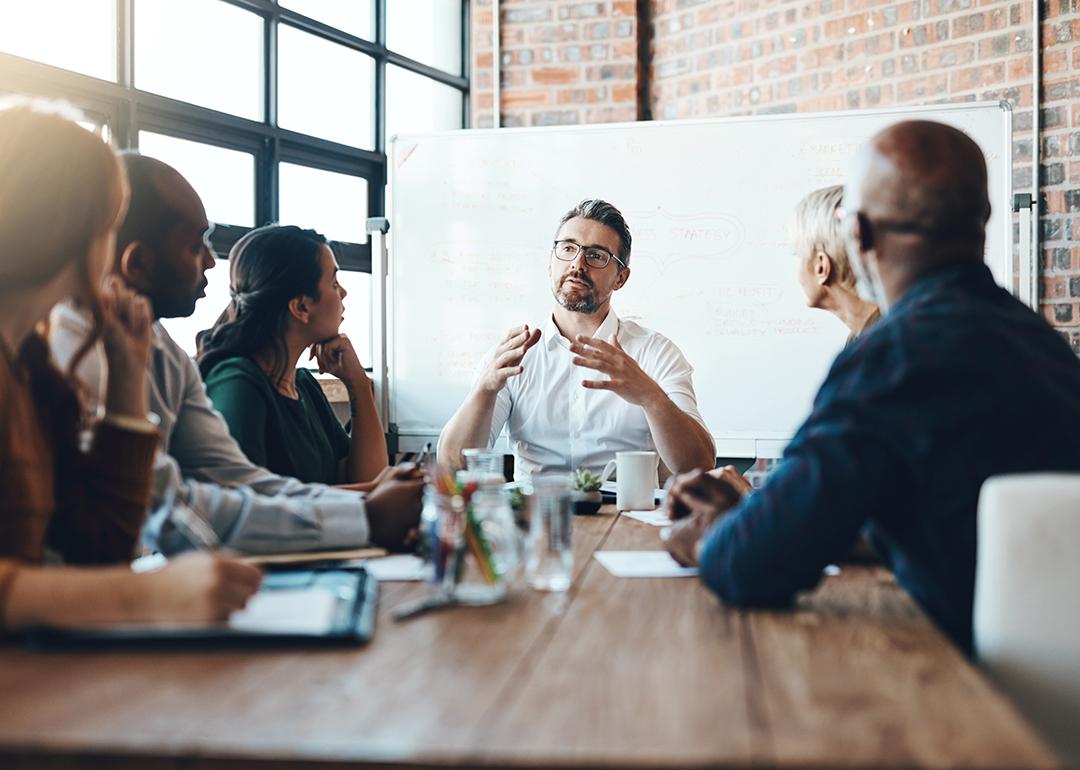 A manager leading a team meeting in a boardroom.