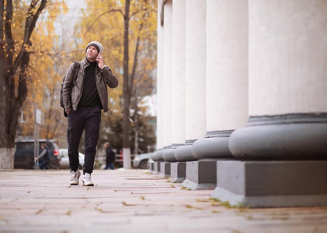 A man walking through the city during autumn.