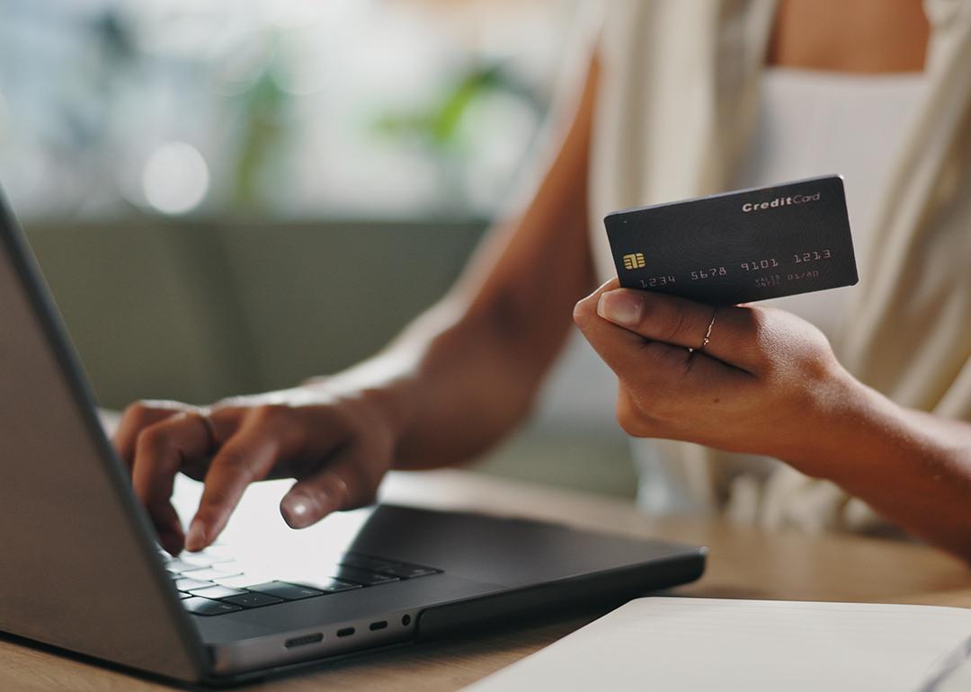 A female business professional typing credit card information for a purchase using her laptop.