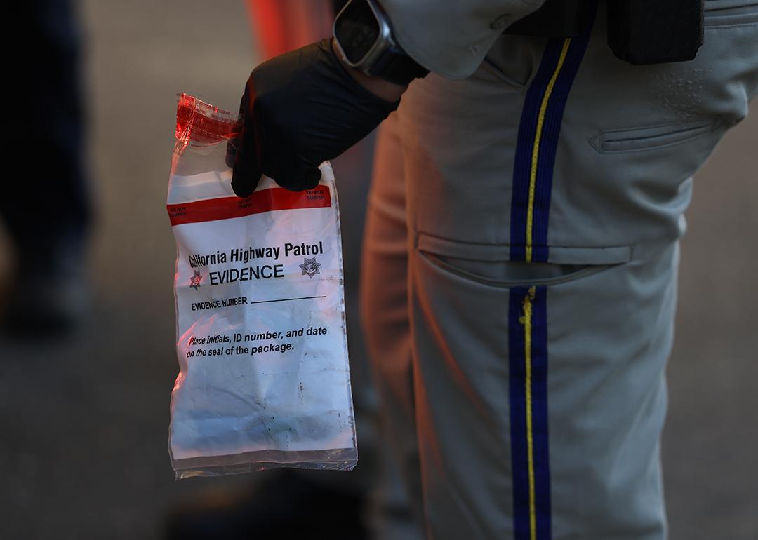 A California Highway Patrol officer holding an evidence bag after taking a suspect into custody.