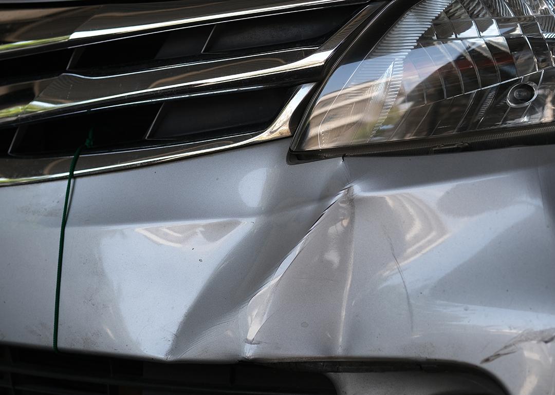 A car's bumper dented from a hit.