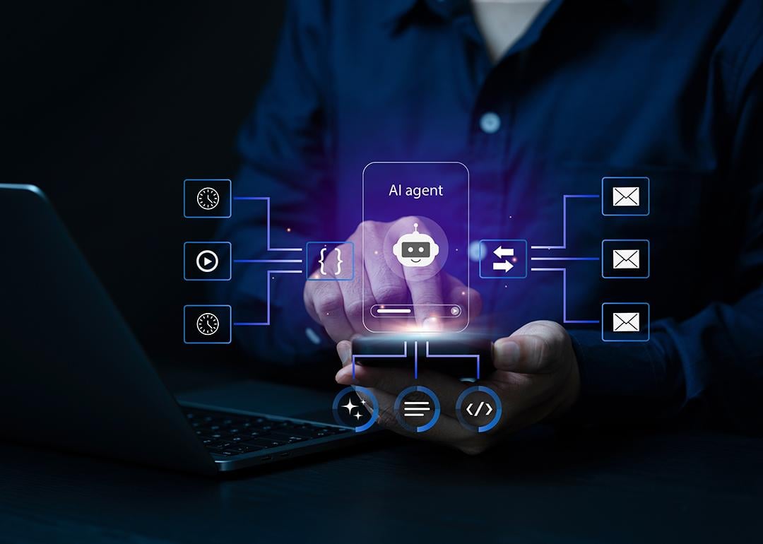 Person using a laptop and smartphone illustrated with AI agentic software graphics.