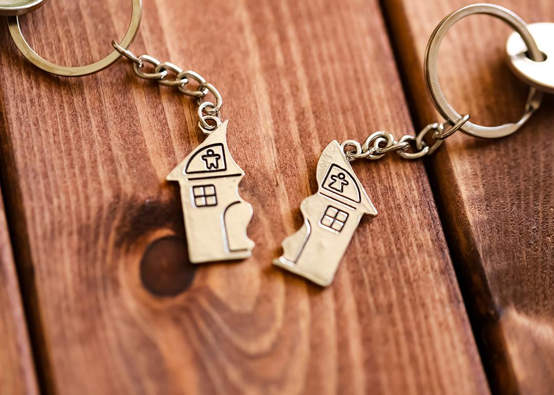 Two halves of a home keyholders as a concept of property sale after divorce.