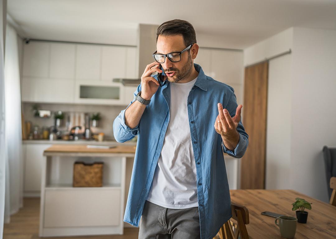 A man at home talking on the phone.