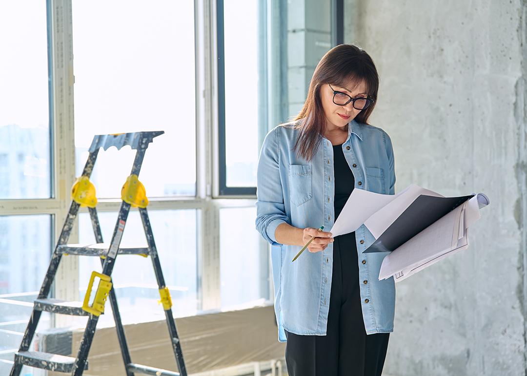 A female interior designer reviewing an apartment renovation plan.