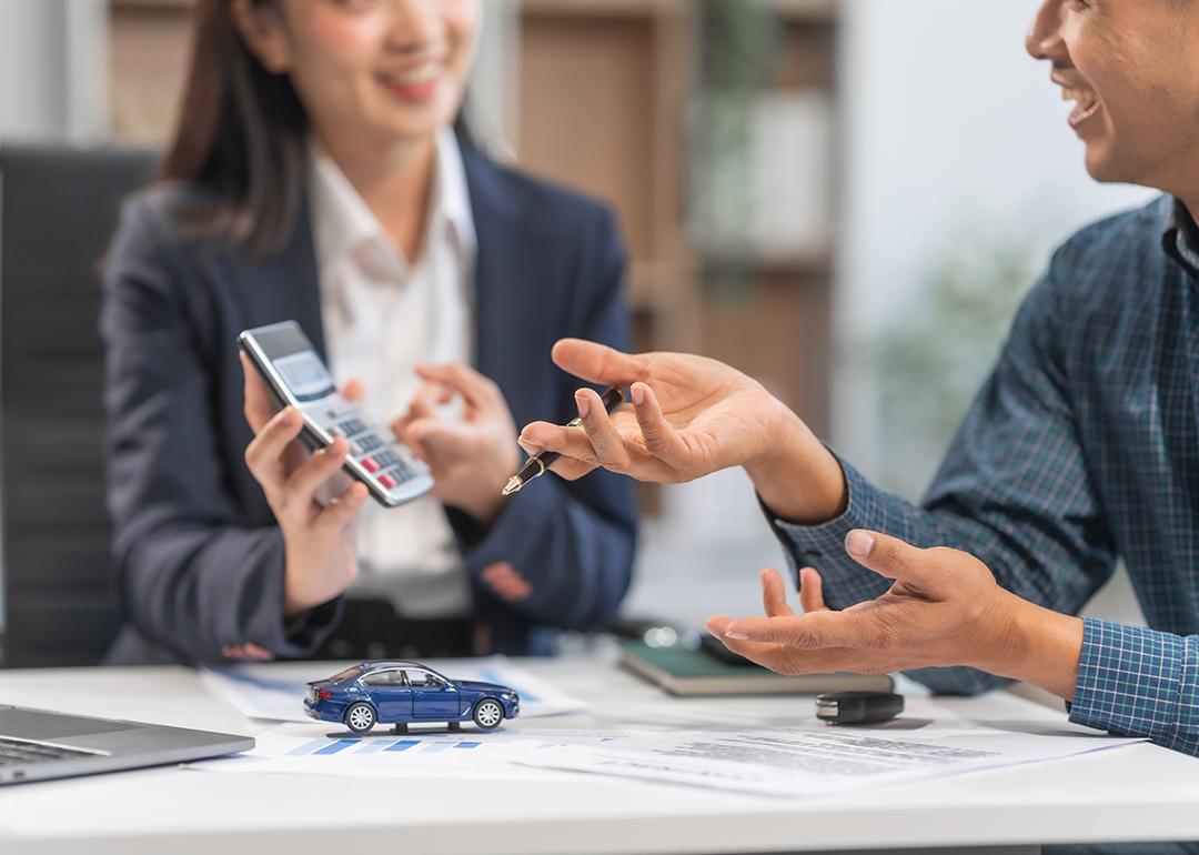 A car loan agent showing a client a sample computation.