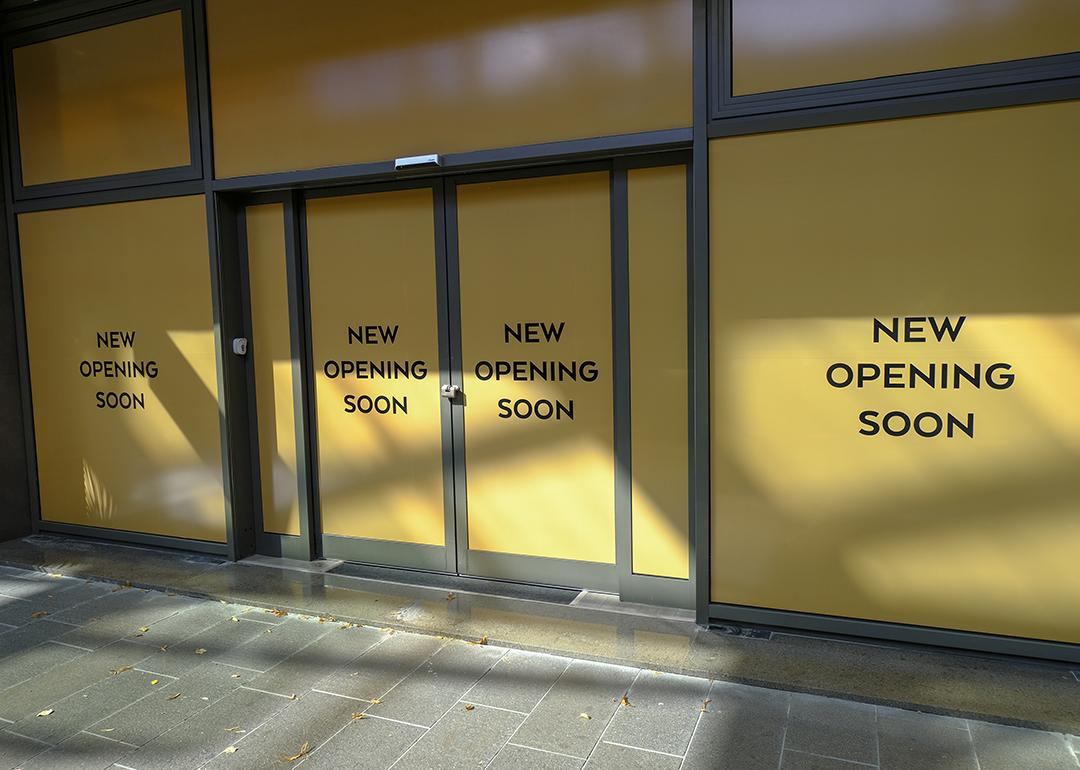 Entrance of a new retail store with 'opening soon' signs.