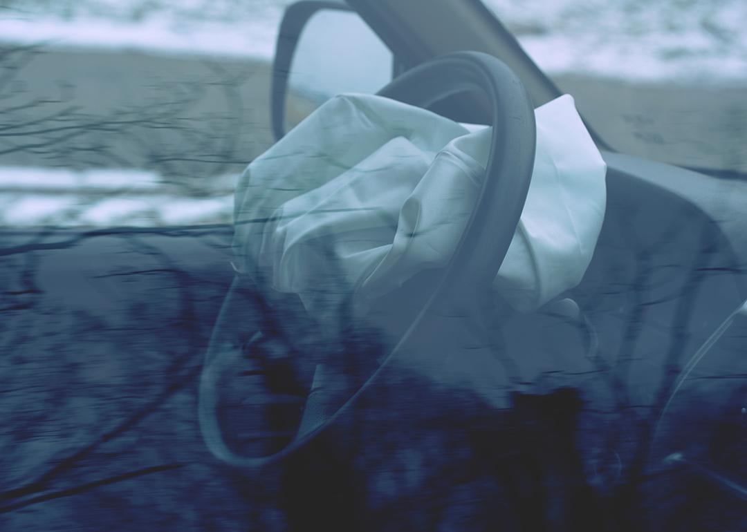 A car's steering wheel with a deployed airbag.