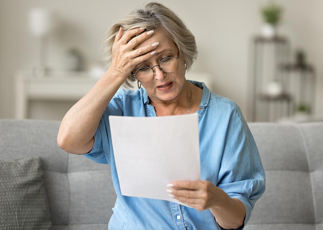 A frustrated senior woman reading a document at home.