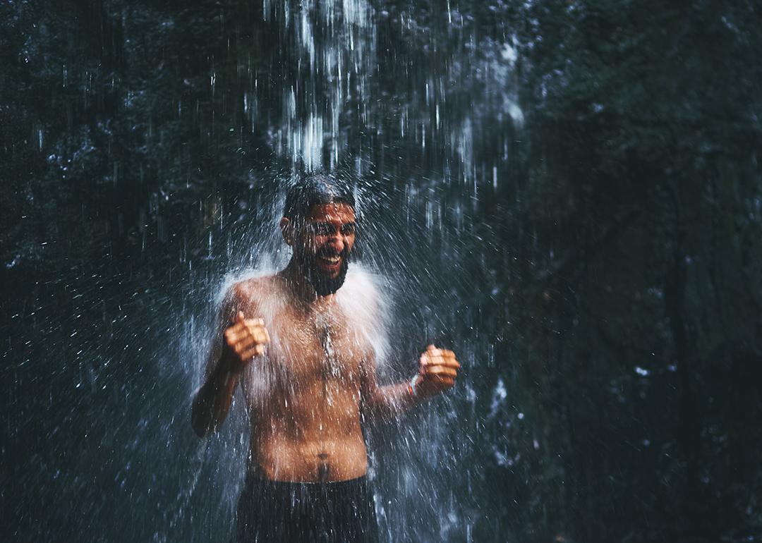 A man under a cold waterfall shower.