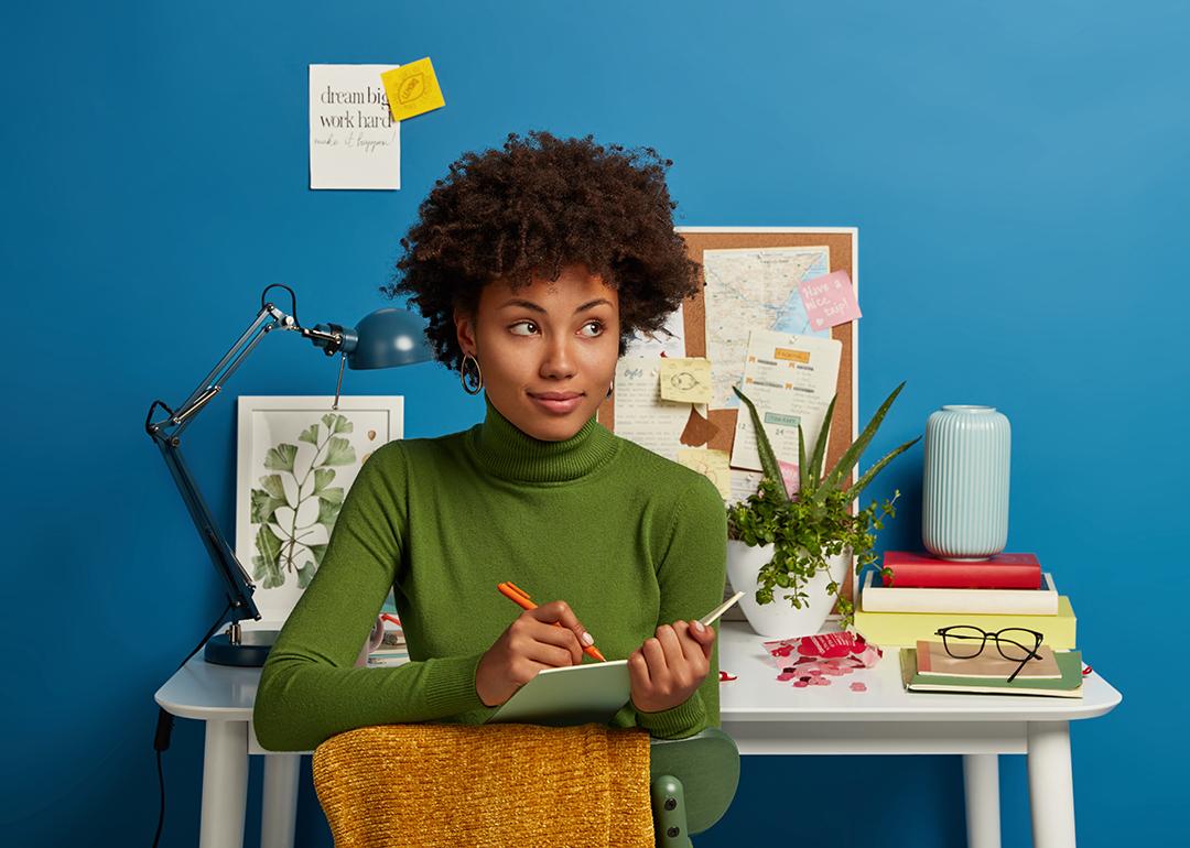 A young woman writing down plans in her notepad.