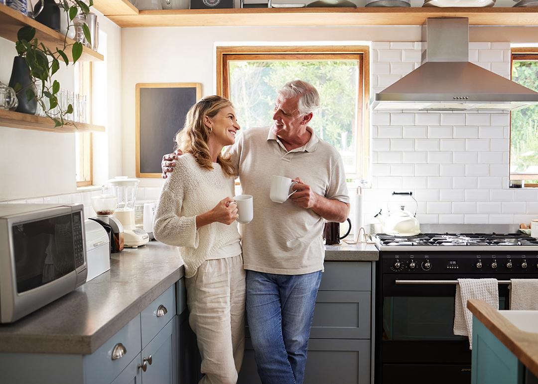 A middle-aged couple having a coffee in their kitchen.