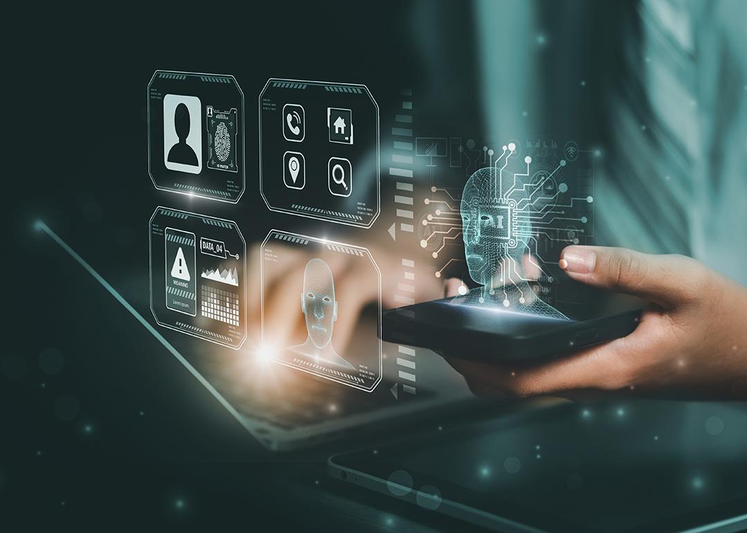 AI and facial recognition graphics illustrated over a person using a laptop and smartphone.