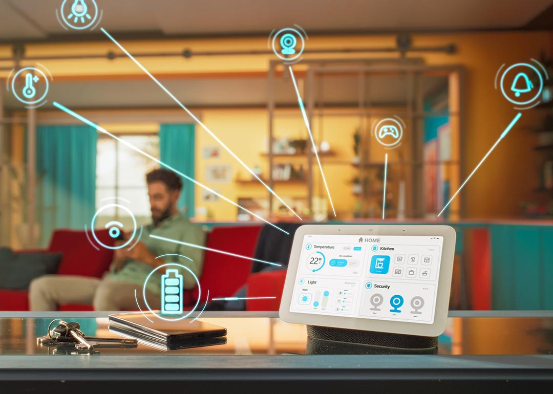 A unified home intelligence system device illustrated with apps and connectivity graphics with the homeowner in a living room as the background.