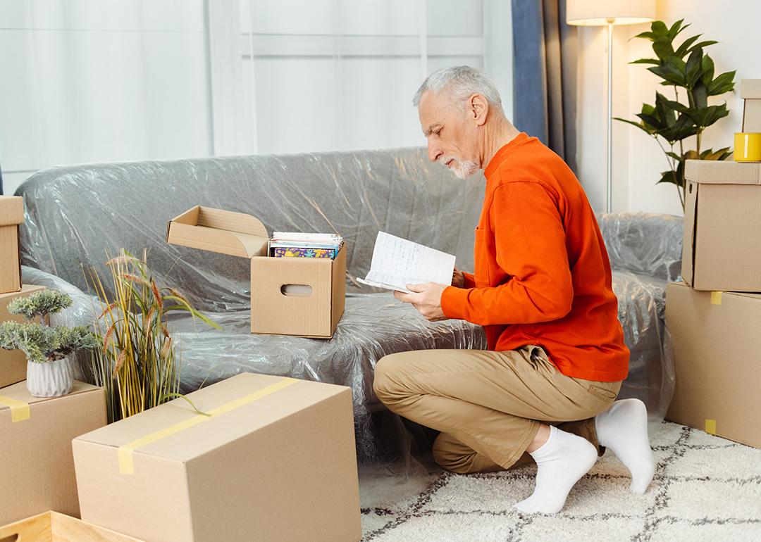 A senior man unpacking boxes of belongings when moving to a new home.