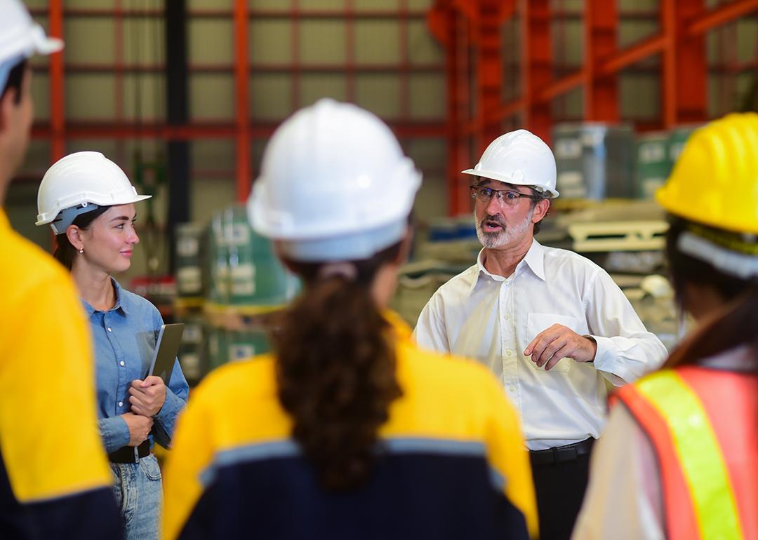 A senior engineering manager briefing a team in their industrial factory workplace.