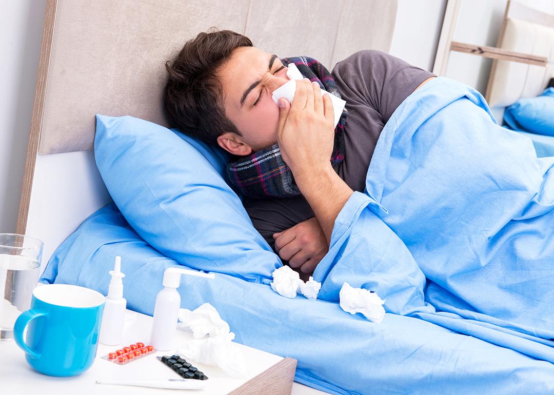 A sick man with flu lying in bed.