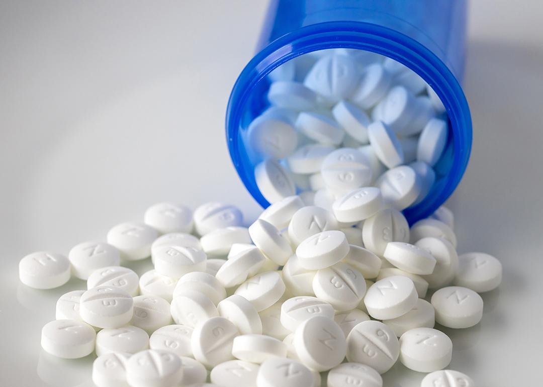 Metformin pills spilling out of a blue prescription bottle.