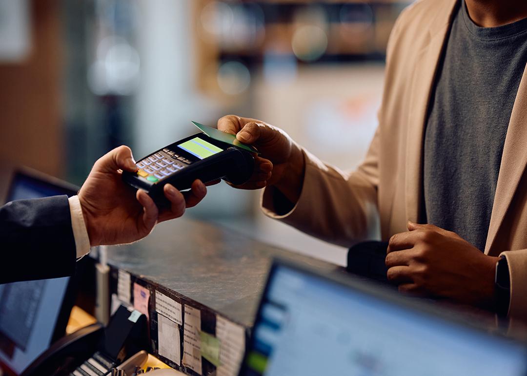 Person taps credit card on a payment terminal at a hotel.