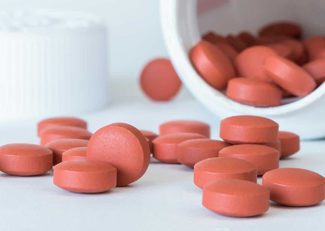 Ibuprofen tablets spilled from a bottle.