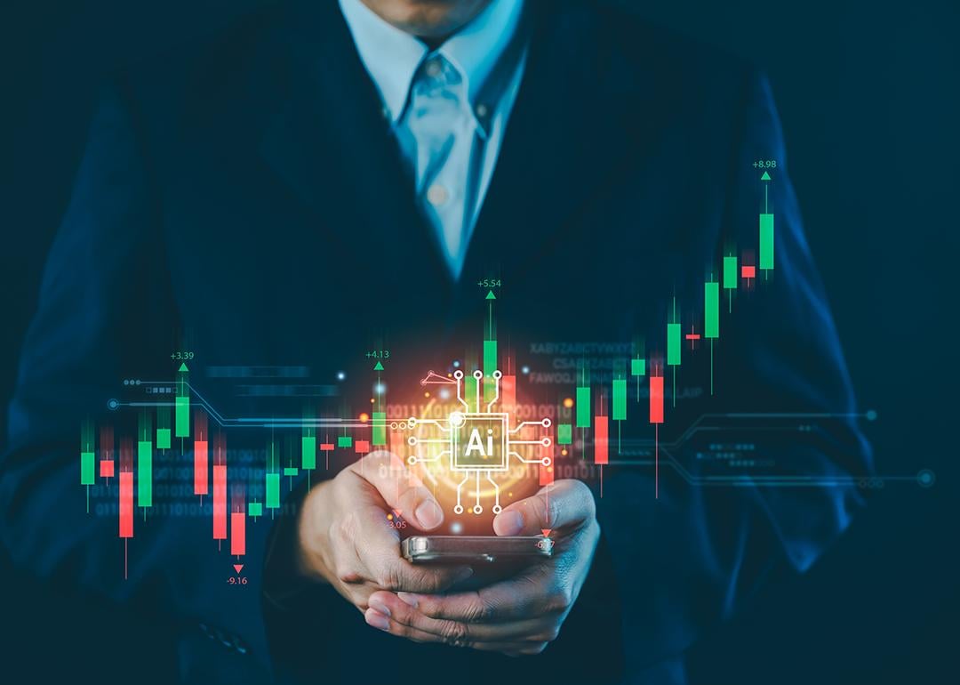A businessman holding a phone illustrated with AI and stock chart graphics.