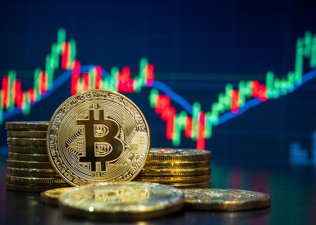 Bitcoin with a background of stock and finance chart graphics.