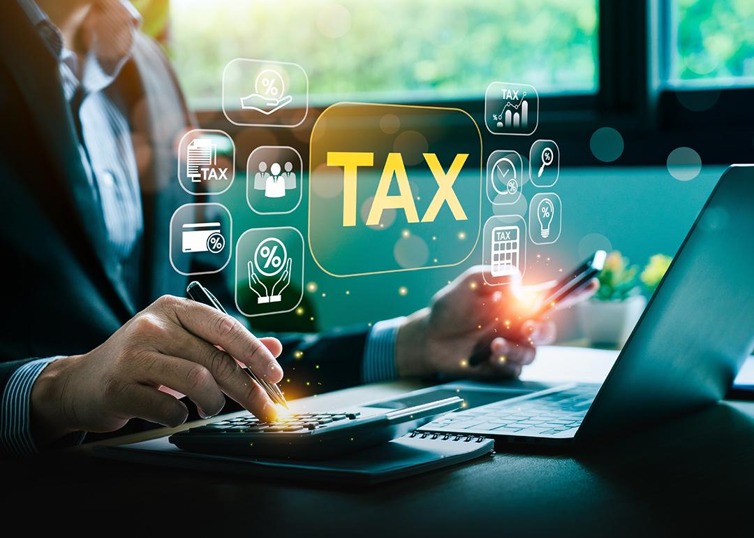 A businessman calculating taxes illustrated with tax deduction software graphics.