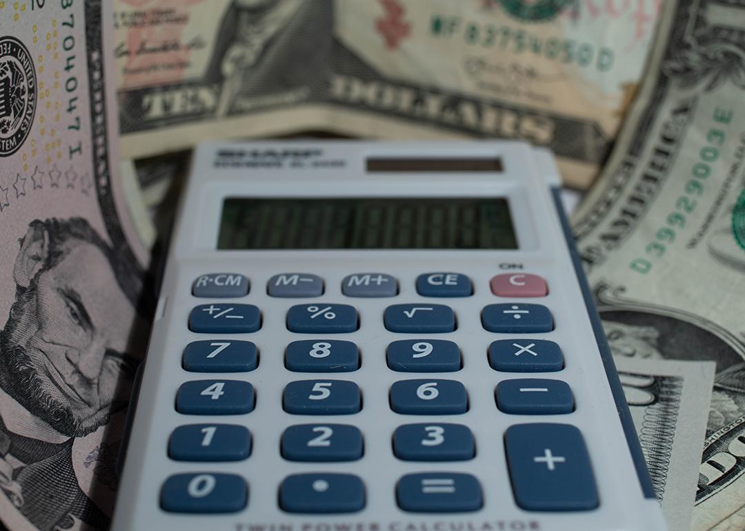 A calculator with a background of US dollar banknotes.