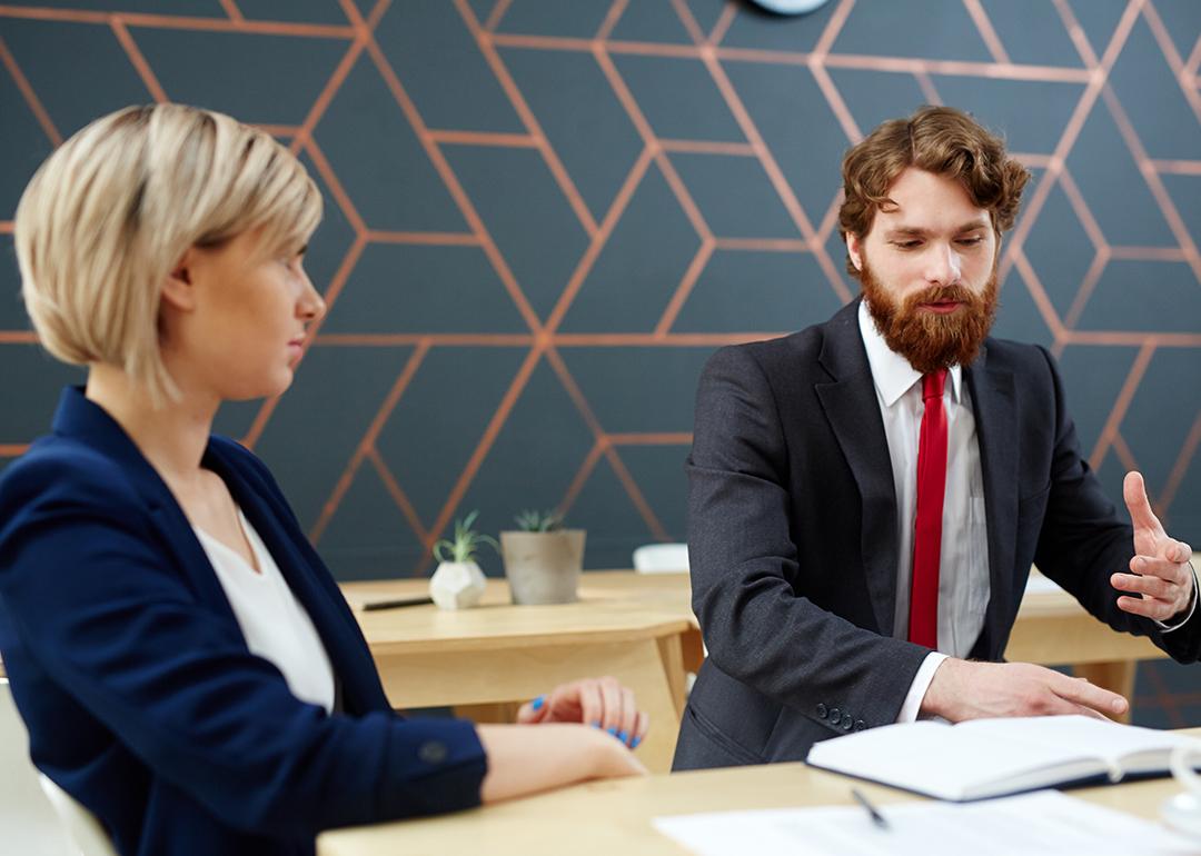 A female employee listening to her colleague at work.
