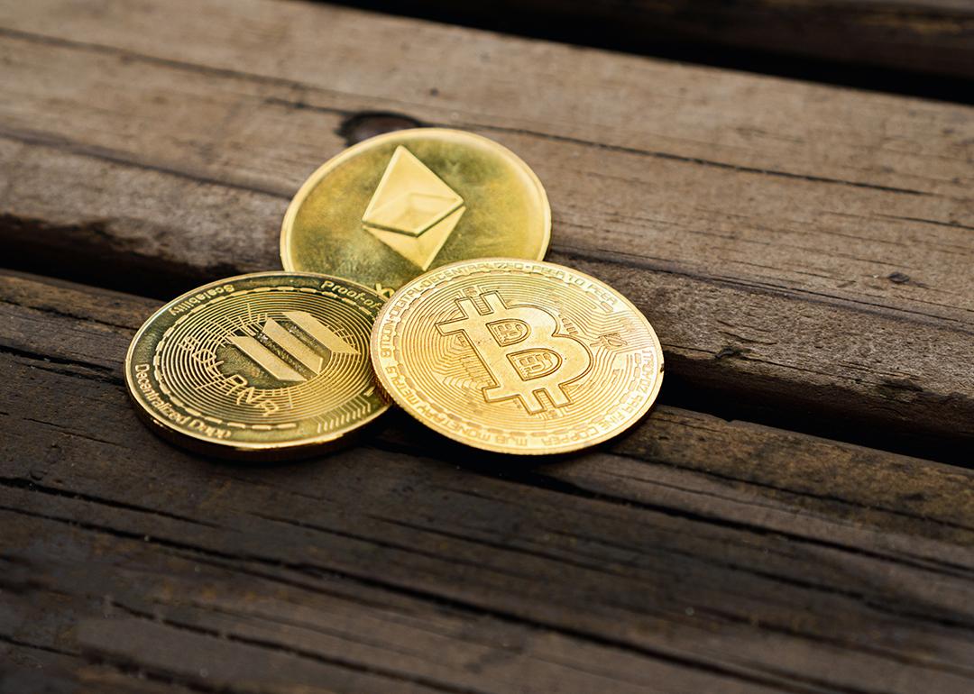 Gold crypto coins on a wooden surface.