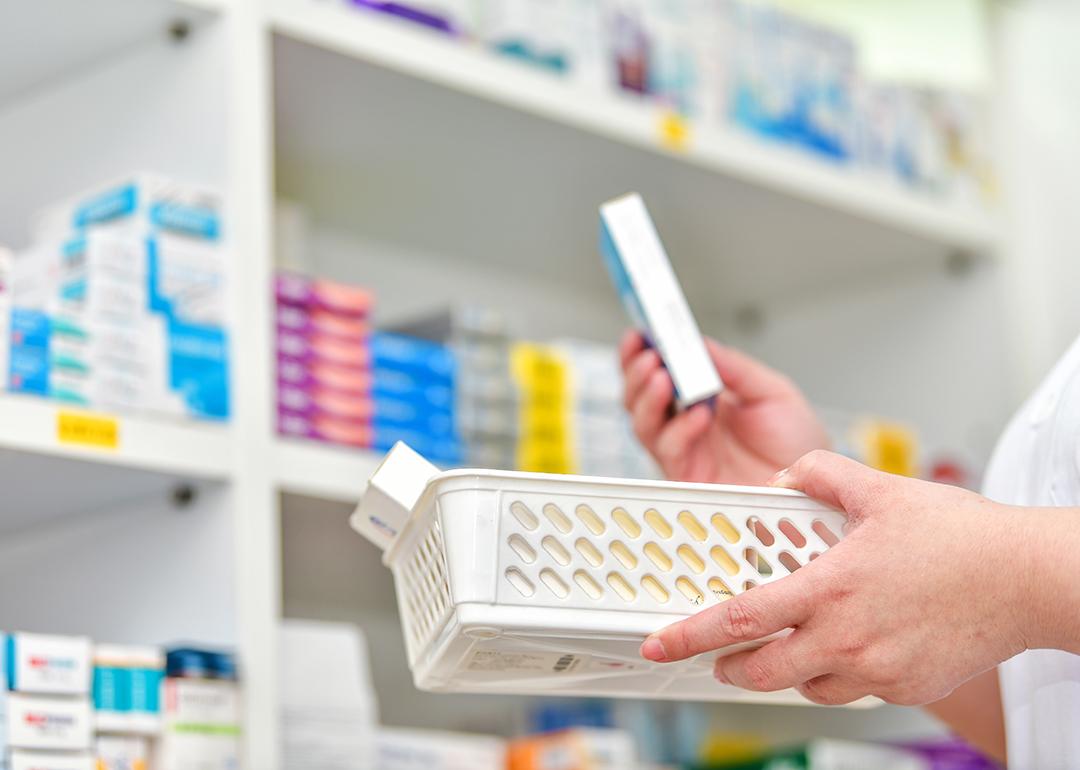 A pharmacist holding a basket to fill out a prescription.