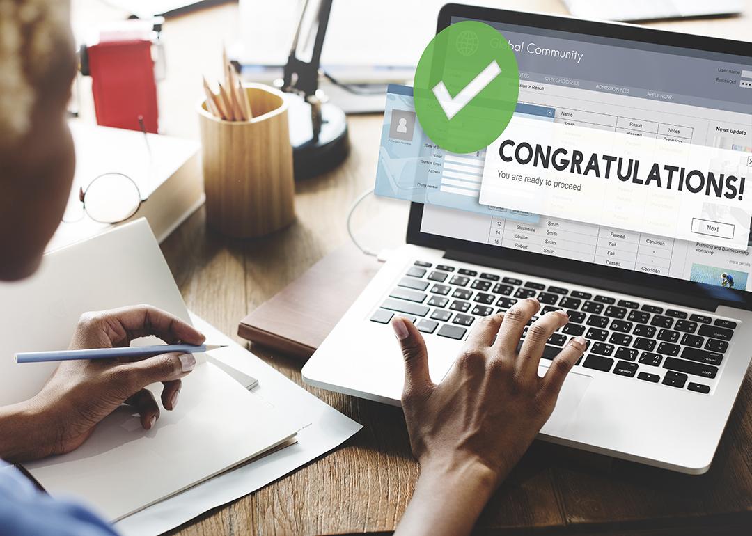 A female jobseeker opening an application with a 'congratulations' message using a laptop.