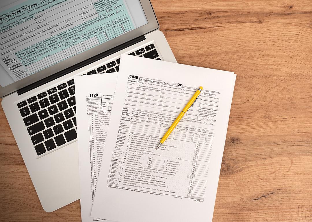 US tax form documents on top of a laptop.