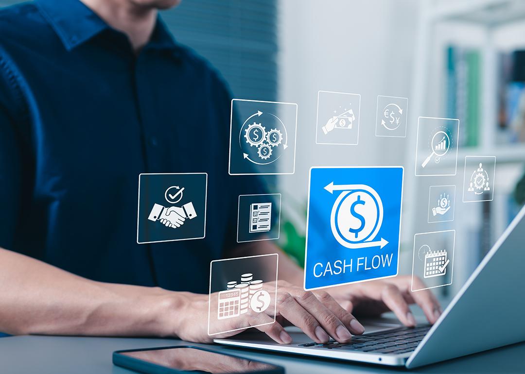 Businessman using laptop illustrated with cash flow application graphics.