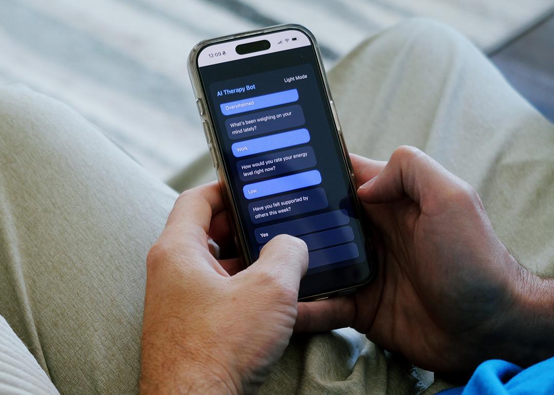 A man having a conversation with an AI therapy bot using a smartphone.