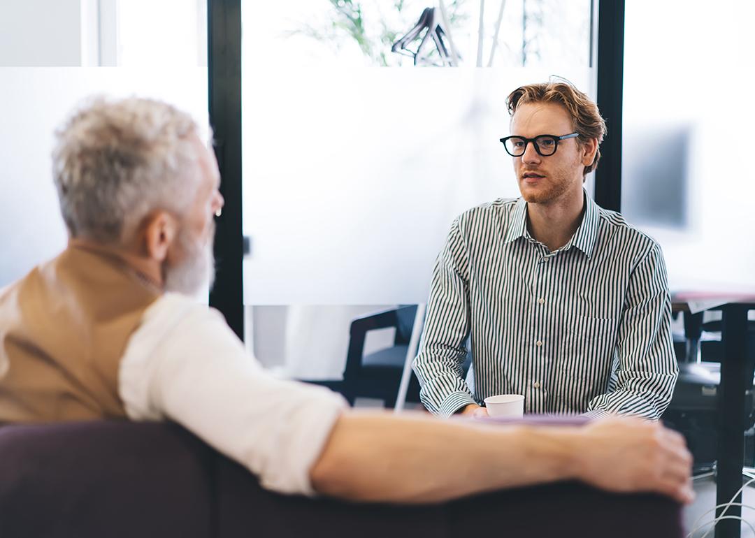A young businessman listening to his senior manager.