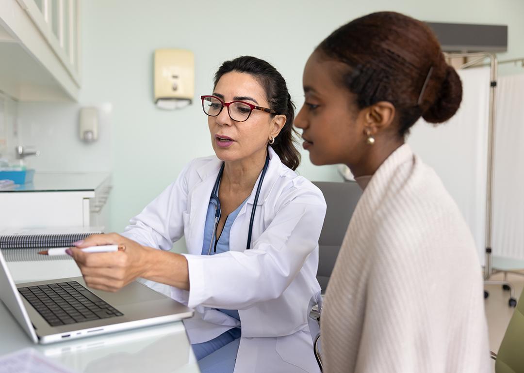 A young black woman going over medical examination results with her female doctor.
