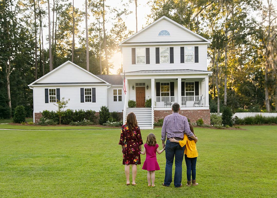 A family of four looking at their newly-constructed home.