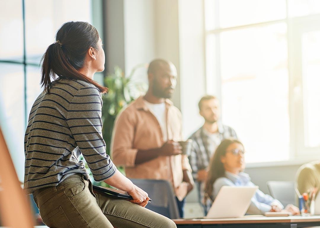 A young woman looking at her business team during a meeting in an office.