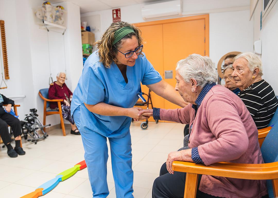 A nurse assisting one of the elderly residents of a nursing home.