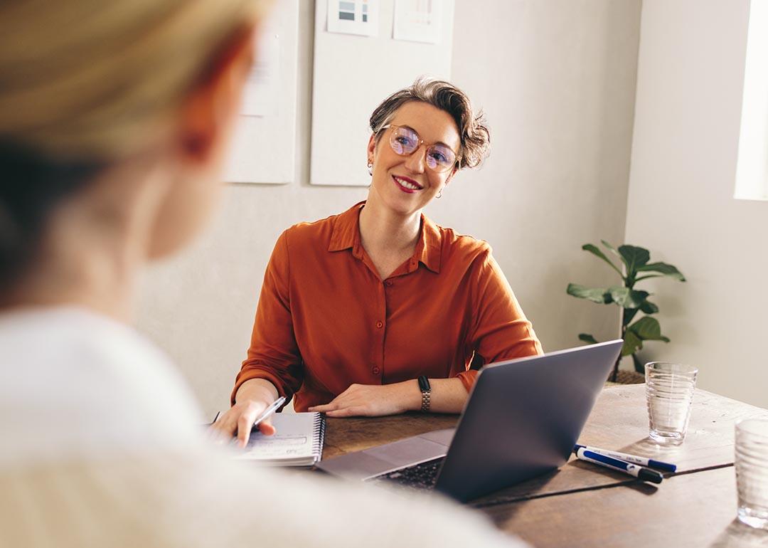 A female hiring manager happily interviewing a job candidate.