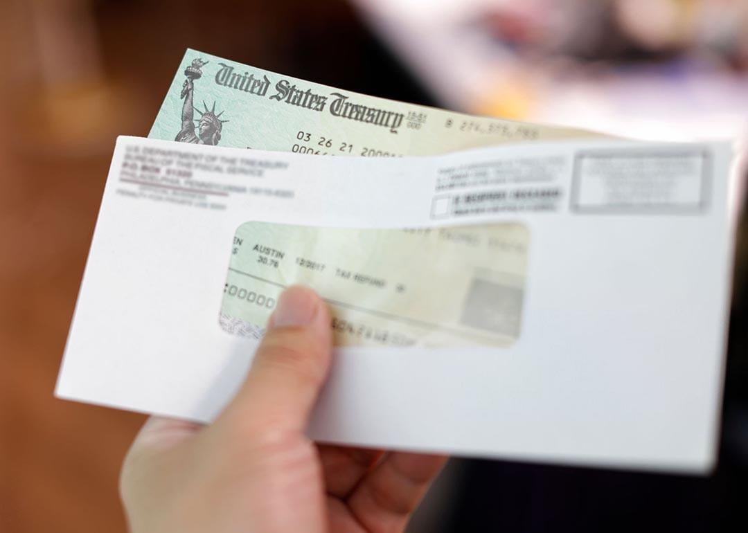 Person holding a tax refund check from government.