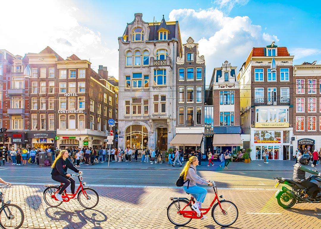 People riding bicycles along Damrak street in central Amsterdam.