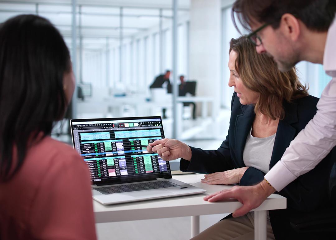A business team reviewing billing reports displayed from a laptop.