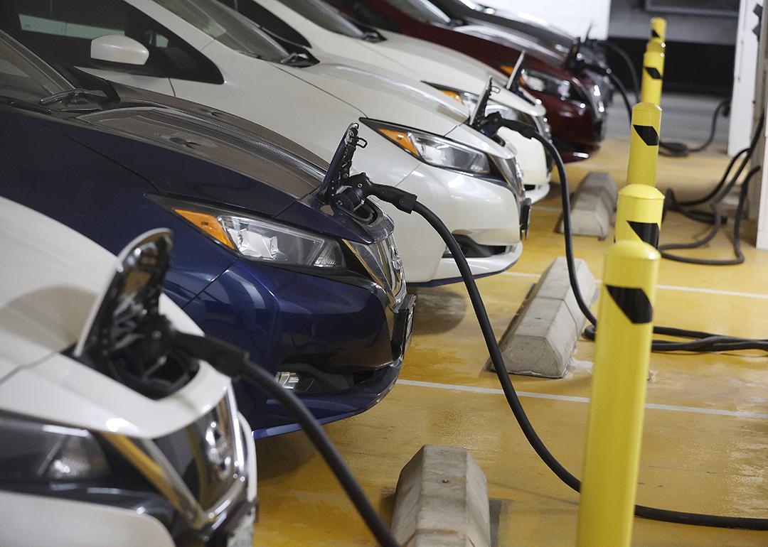 A row of parked electric cars being charged.