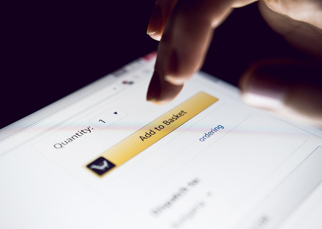 Person about to tap 'Add to basket' button on a shopping app.