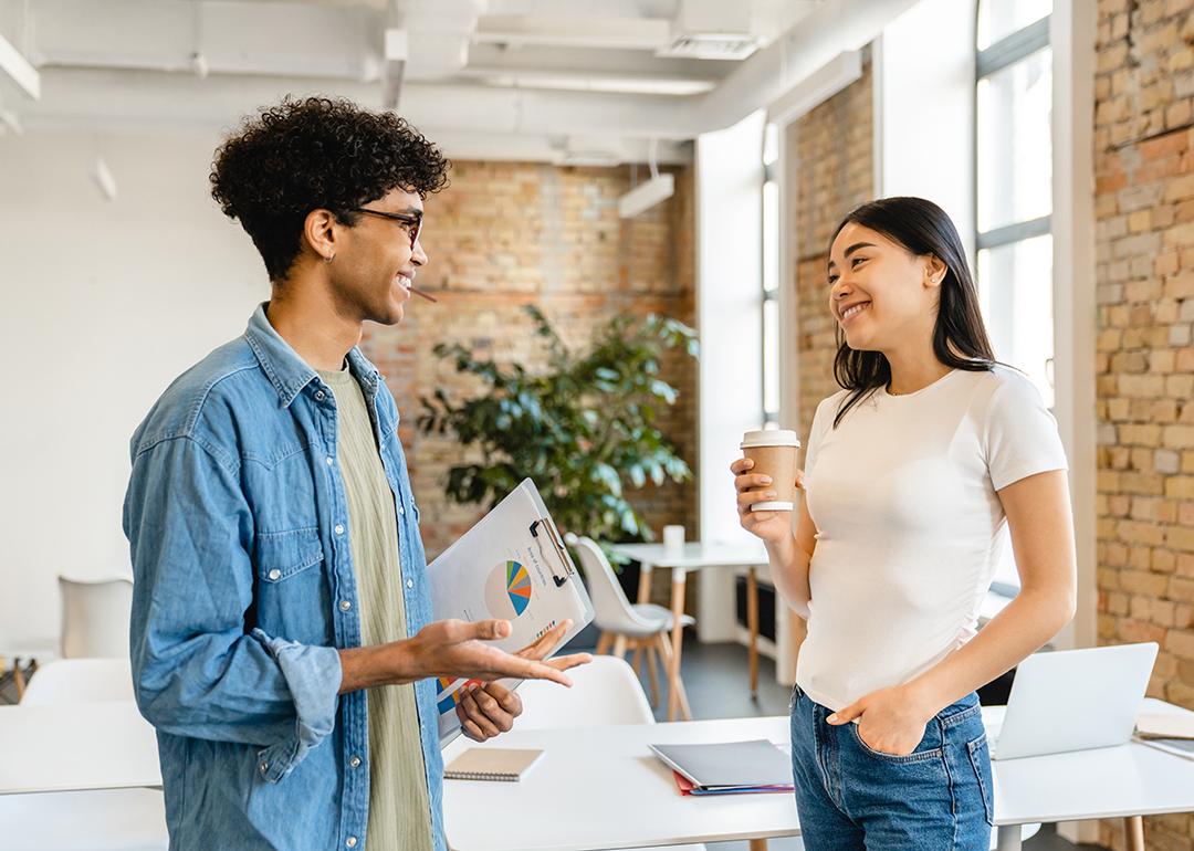 A young man and woman talking in a coworking space.