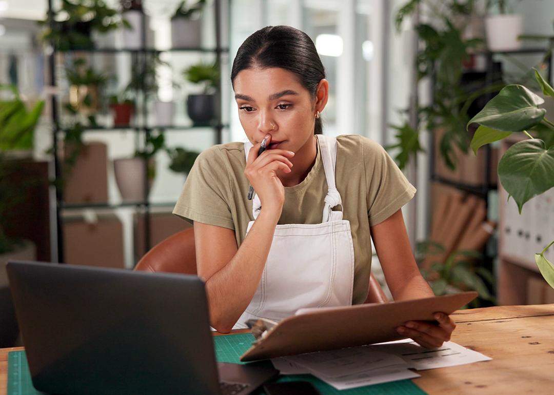 A female small flower business owner reviewing reports in the store.