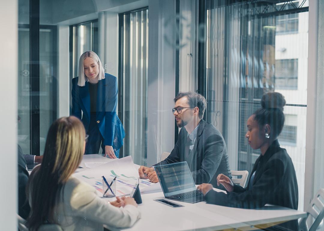 A business team inside a glass meeting room.